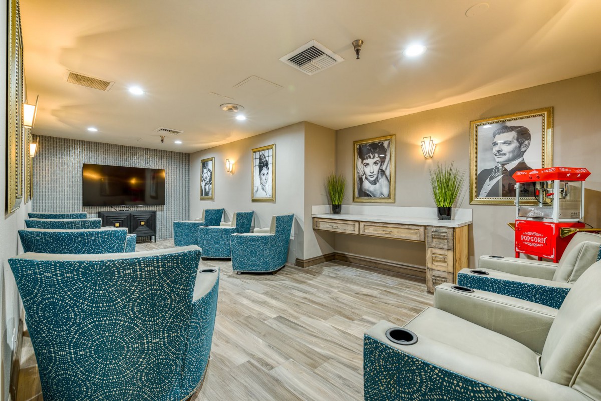 A modern lounge area with comfortable seating and stylish decor, featuring artwork and plants.