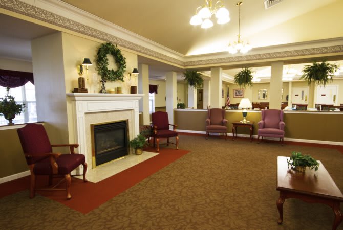 A cozy lobby area featuring a fireplace, comfortable seating, and decorative plants.