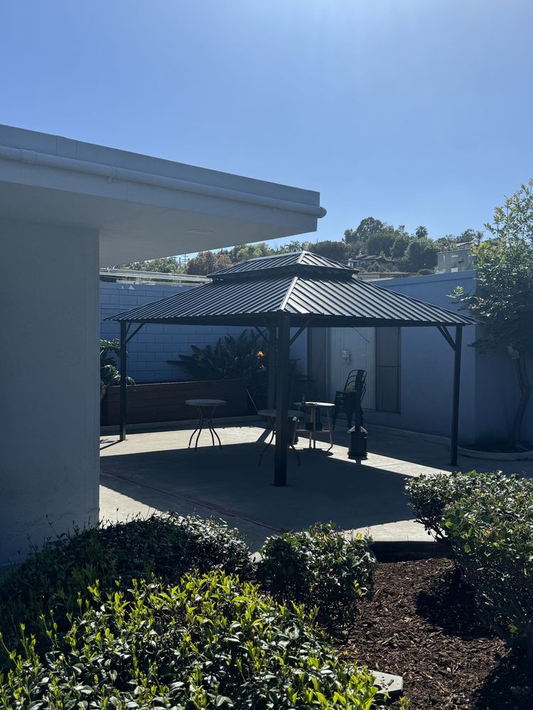 A sunny day in a landscaped backyard with a gazebo and patio.