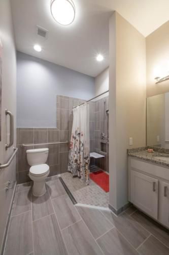 A modern bathroom with a toilet, shower, and vanity.