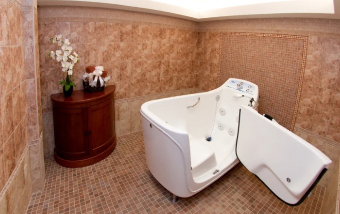 A luxurious bathroom featuring a walk-in bathtub and elegant tile walls.