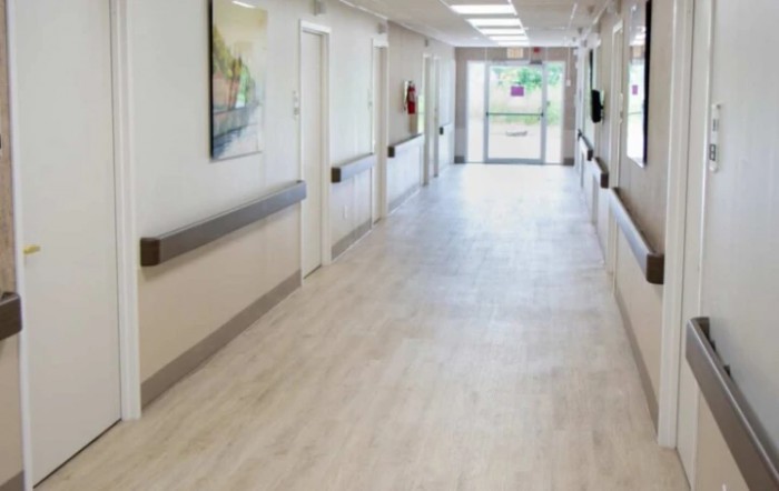 An empty hospital corridor with bright lighting.