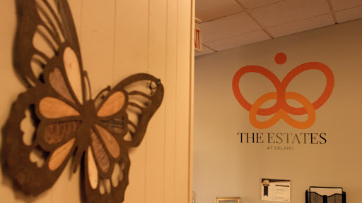 A decorative butterfly hangs on the wall next to a business logo, creating a serene atmosphere.