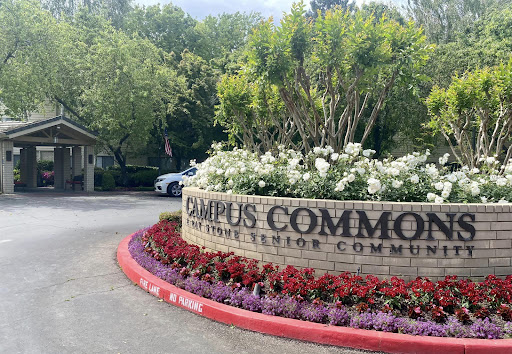 Entrance to Campus Commons Senior Community, showcasing beautiful landscaping and a welcoming sign.