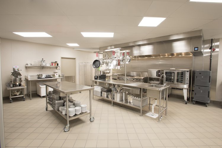 A clean and organized commercial kitchen with stainless steel appliances and surfaces.