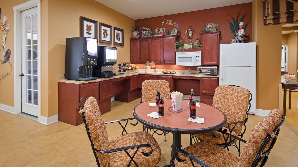 A cozy kitchen and dining area with a table set for refreshments, surrounded by modern appliances.
