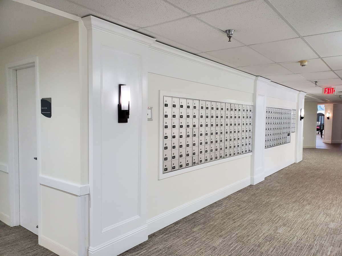A hallway in an apartment building featuring rows of mailboxes.
