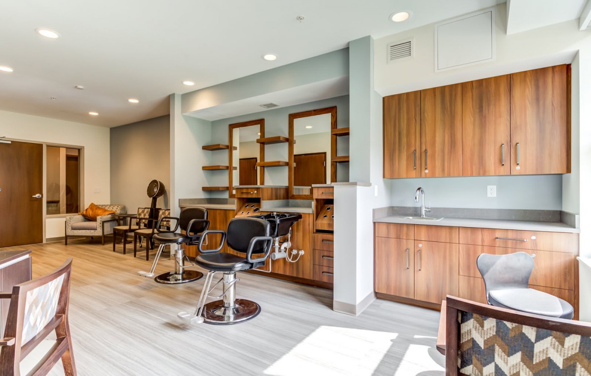 A modern barber shop interior featuring stylish chairs and wooden cabinetry.