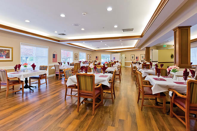An elegant dining room with neatly arranged tables and chairs.