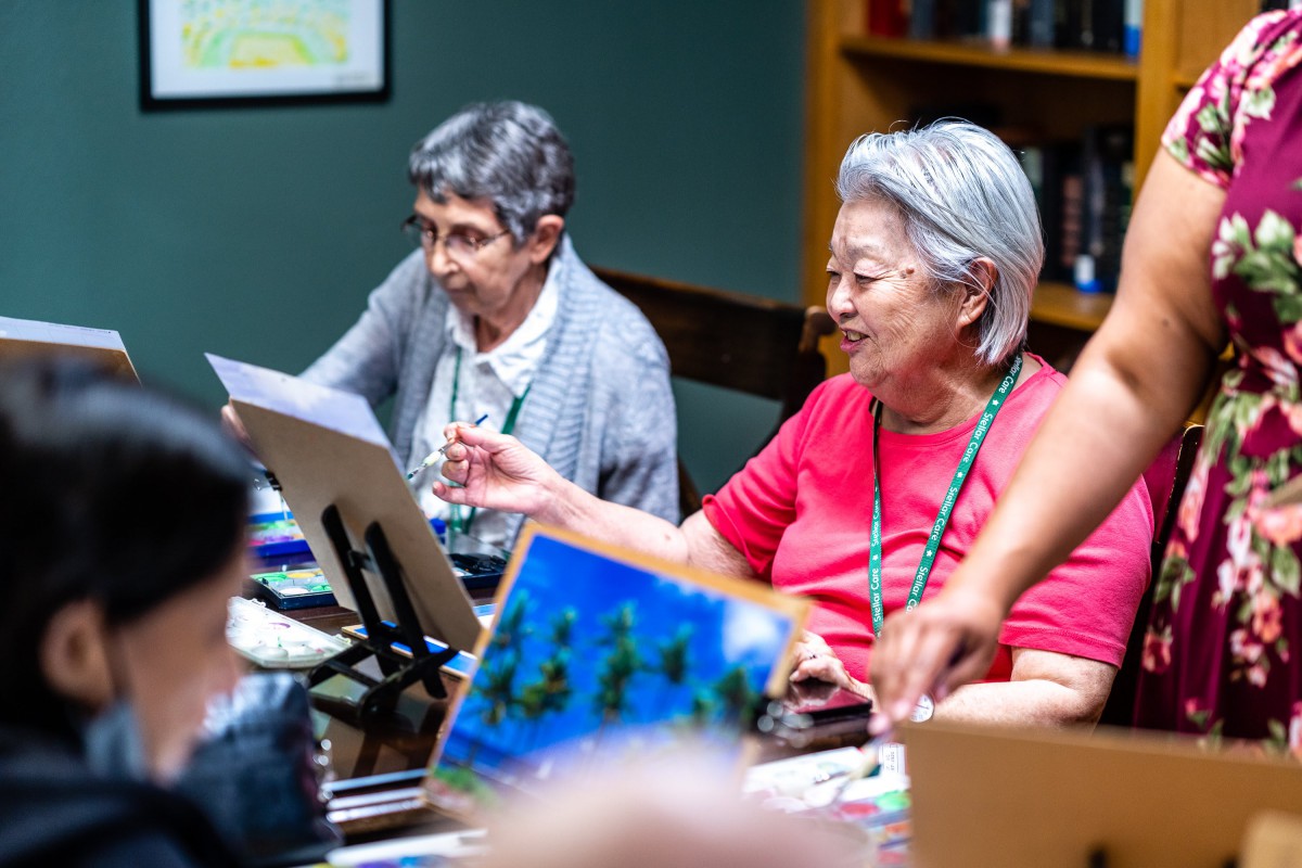A group of seniors engaged in a painting class, enjoying their artistic hobby.