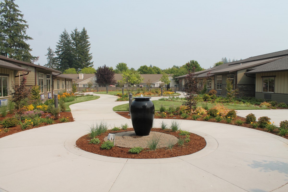A beautifully landscaped courtyard with pathways and a central decorative urn.
