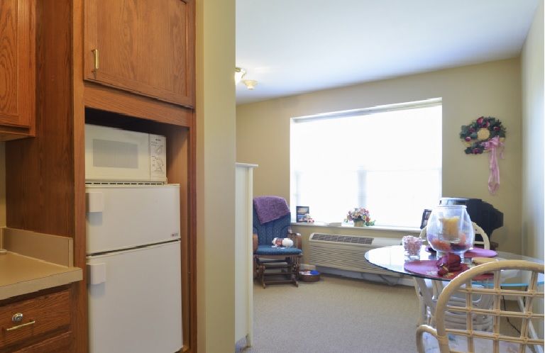 A cozy living space with a kitchen area, featuring a window letting in natural light.