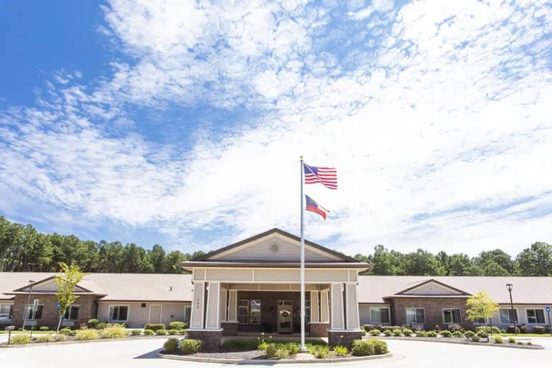 A building with flags in front under a partly cloudy sky.