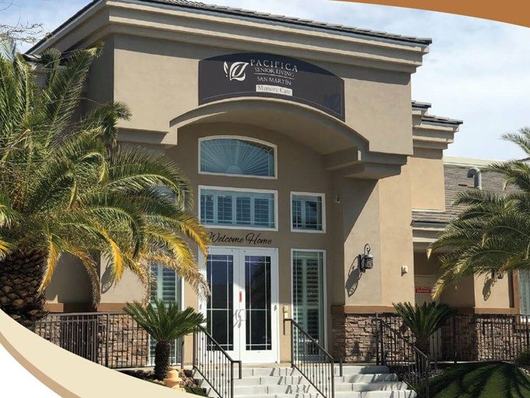 A commercial building entrance featuring palm trees and a modern architectural design.
