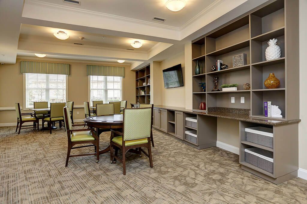 A modern library interior featuring bookshelves, tables, and chairs for reading.
