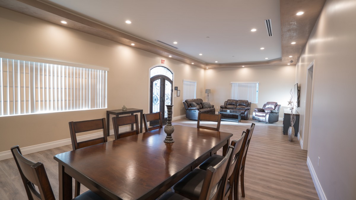 A spacious open-concept living and dining area with elegant furniture and warm lighting.