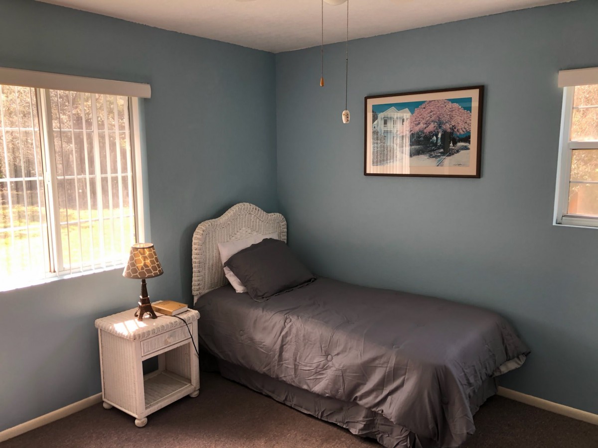 A cozy bedroom with a single bed and nightstand.