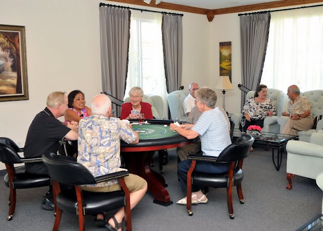 A group of people sitting around a table having a conversation in an indoor setting.