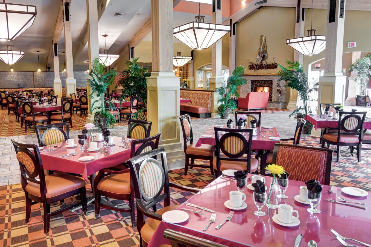 A beautifully decorated restaurant interior featuring elegantly set tables and plush seating.