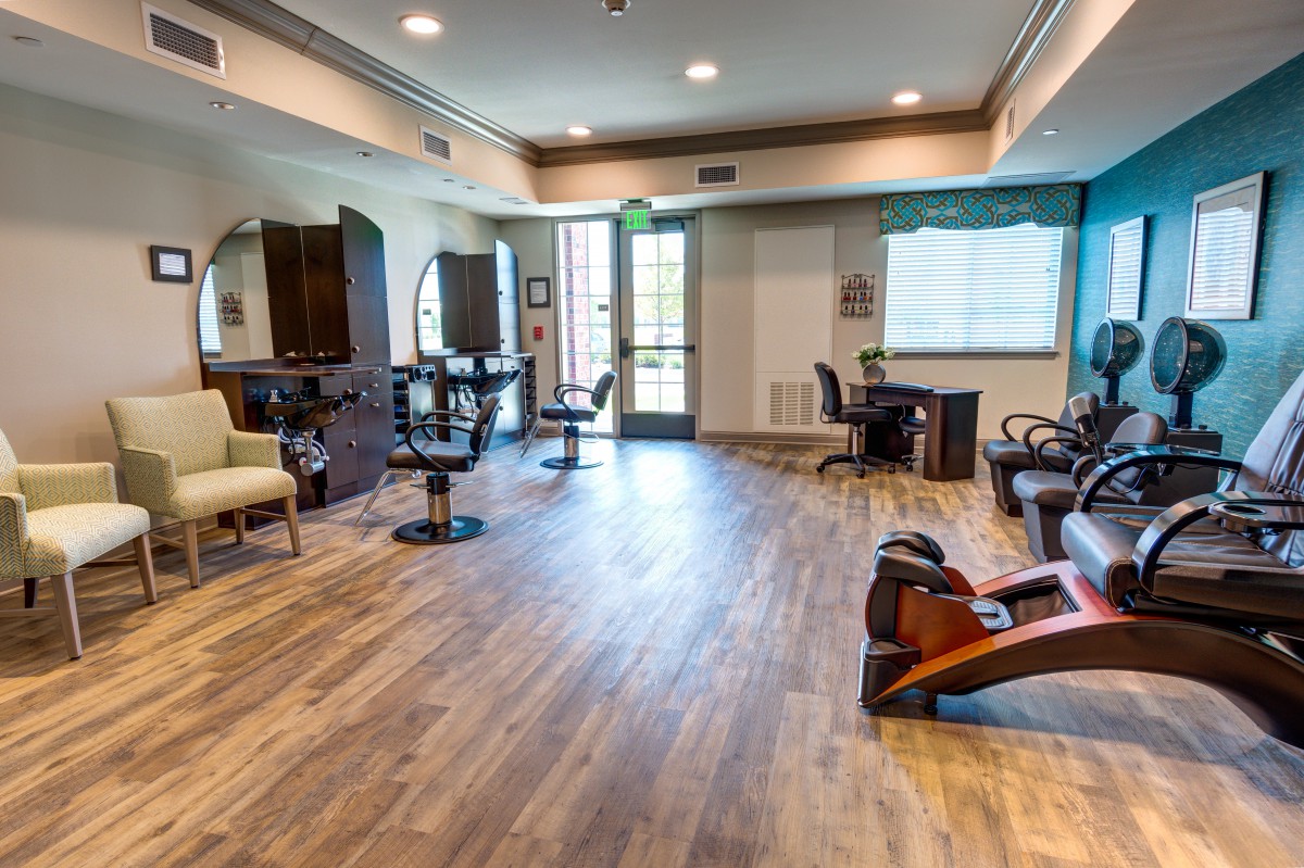 A modern salon interior with various chairs and equipment.
