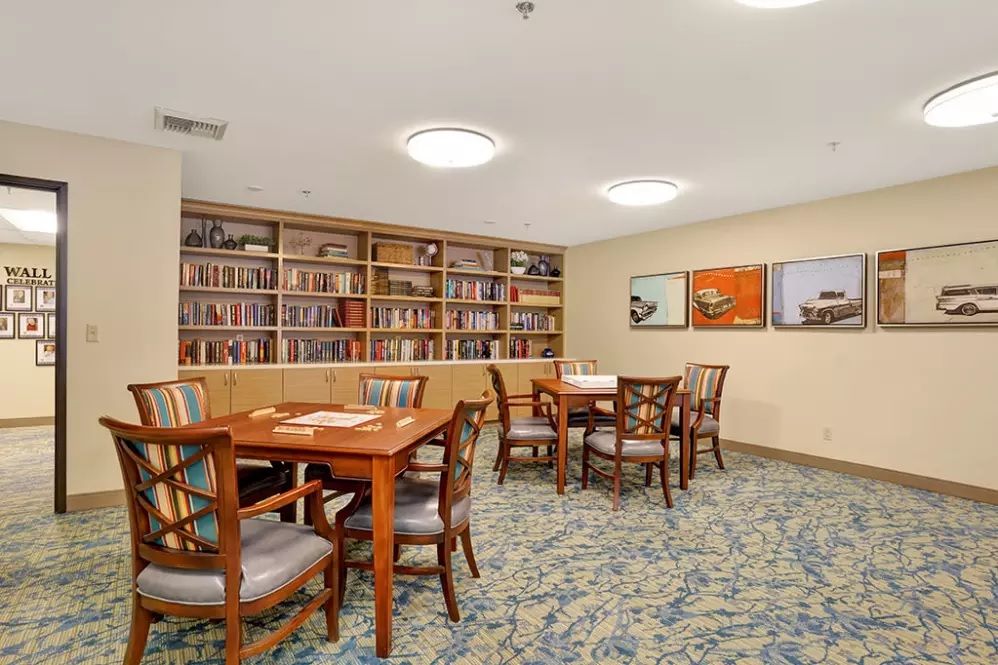 A cozy library room with bookshelves and seating areas.