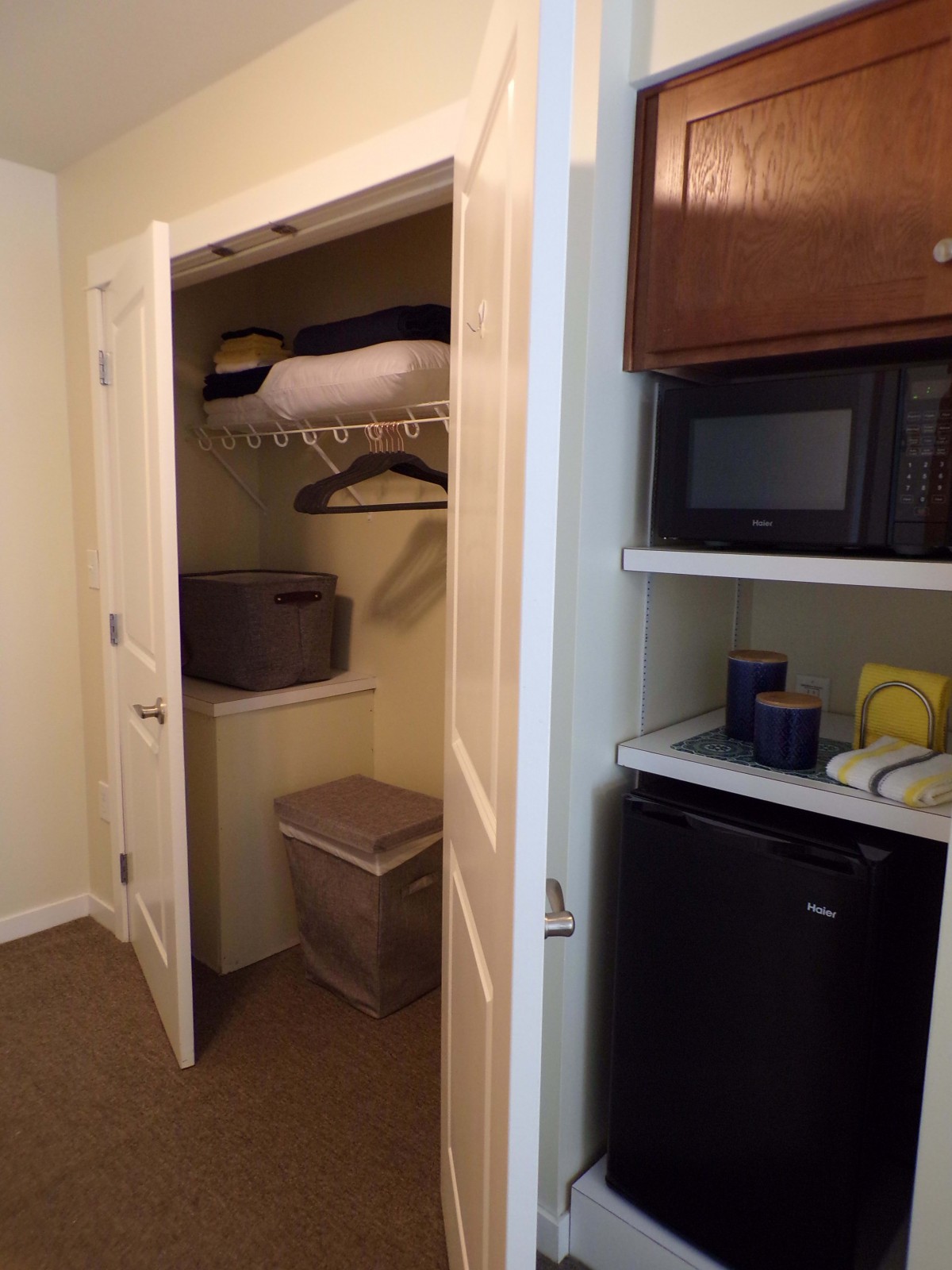 A small closet area with a laundry basket, shelves, and appliances.