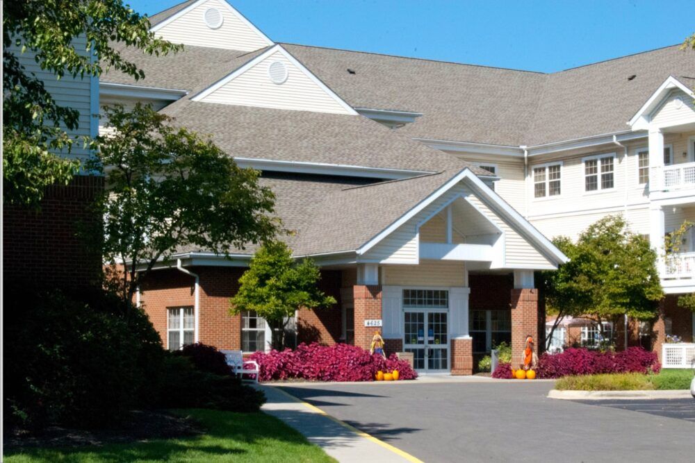 A well-maintained building entrance with colorful flowers and landscaping.