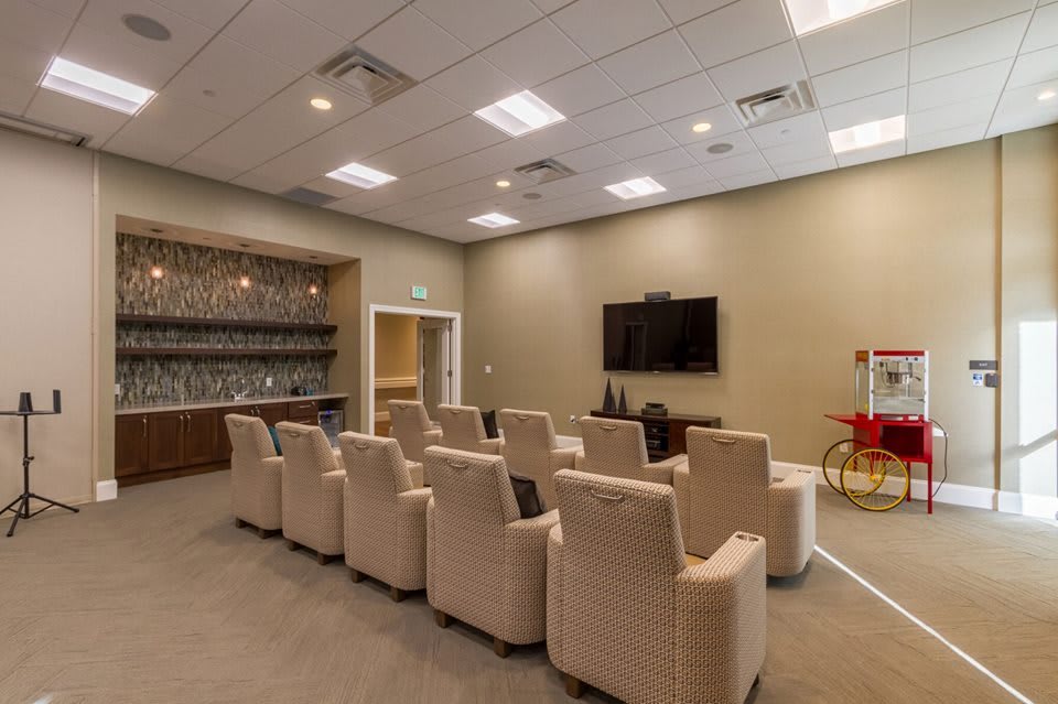 A comfortable home theater setup with multiple chairs facing a large TV screen, ideal for group viewings.