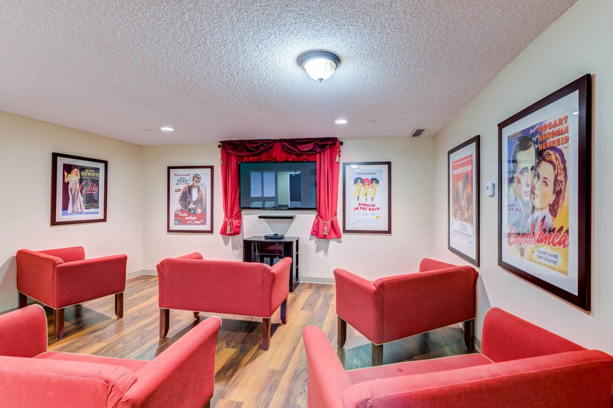 A cozy home theater with red chairs and movie posters on the walls.