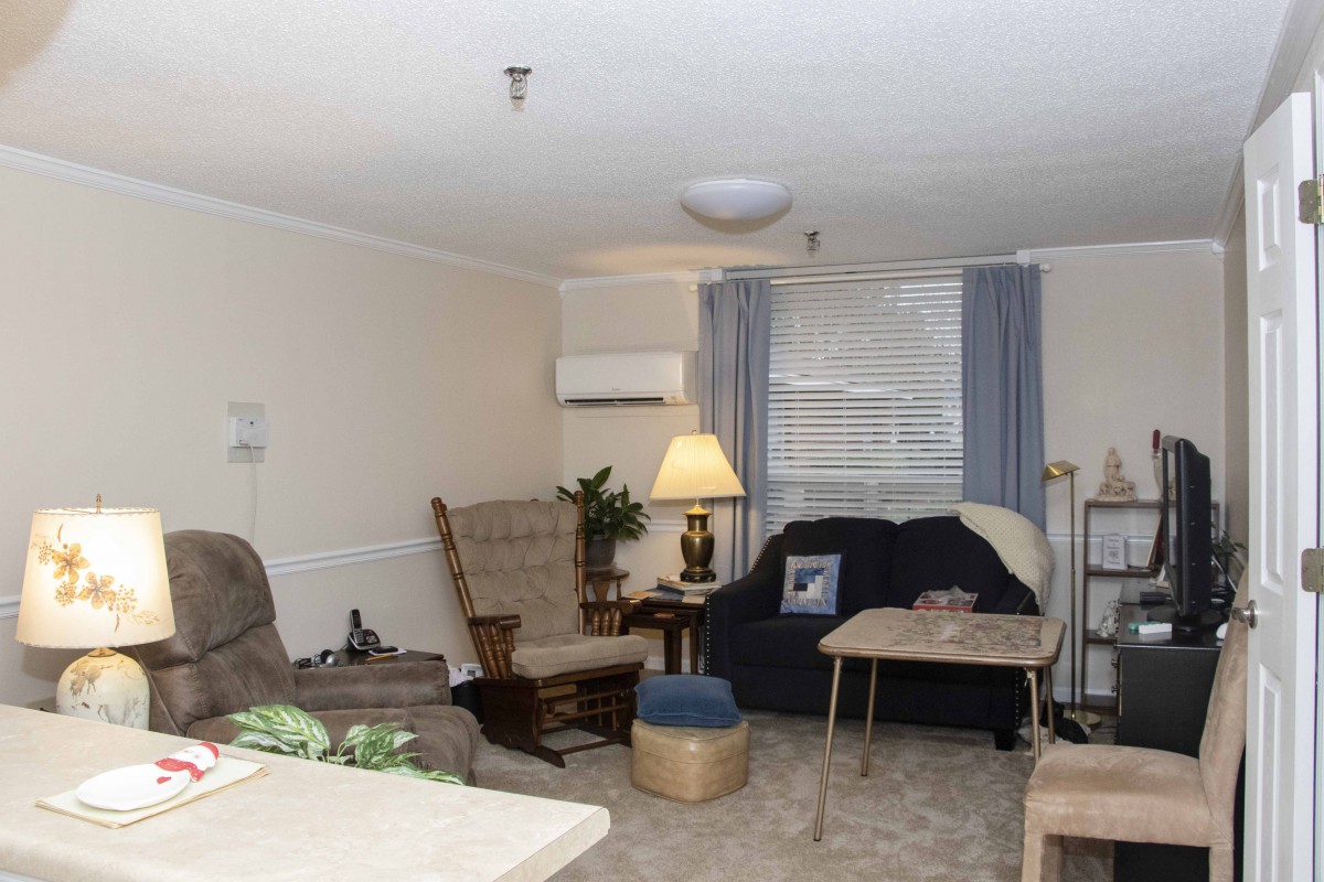 A cozy living room with comfortable seating, a lamp, and a small table.