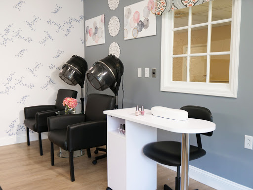 A cozy nail salon featuring a manicure station and comfortable seating, complemented by stylish decor.