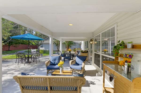 A cozy patio with wicker furniture and blue cushions offering a comfortable outdoor relaxation space.