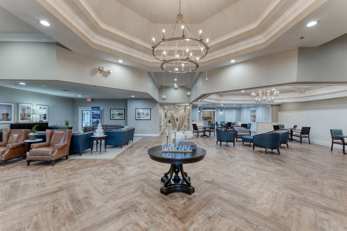 A spacious, elegantly designed lobby featuring a central chandelier and comfortable seating areas.