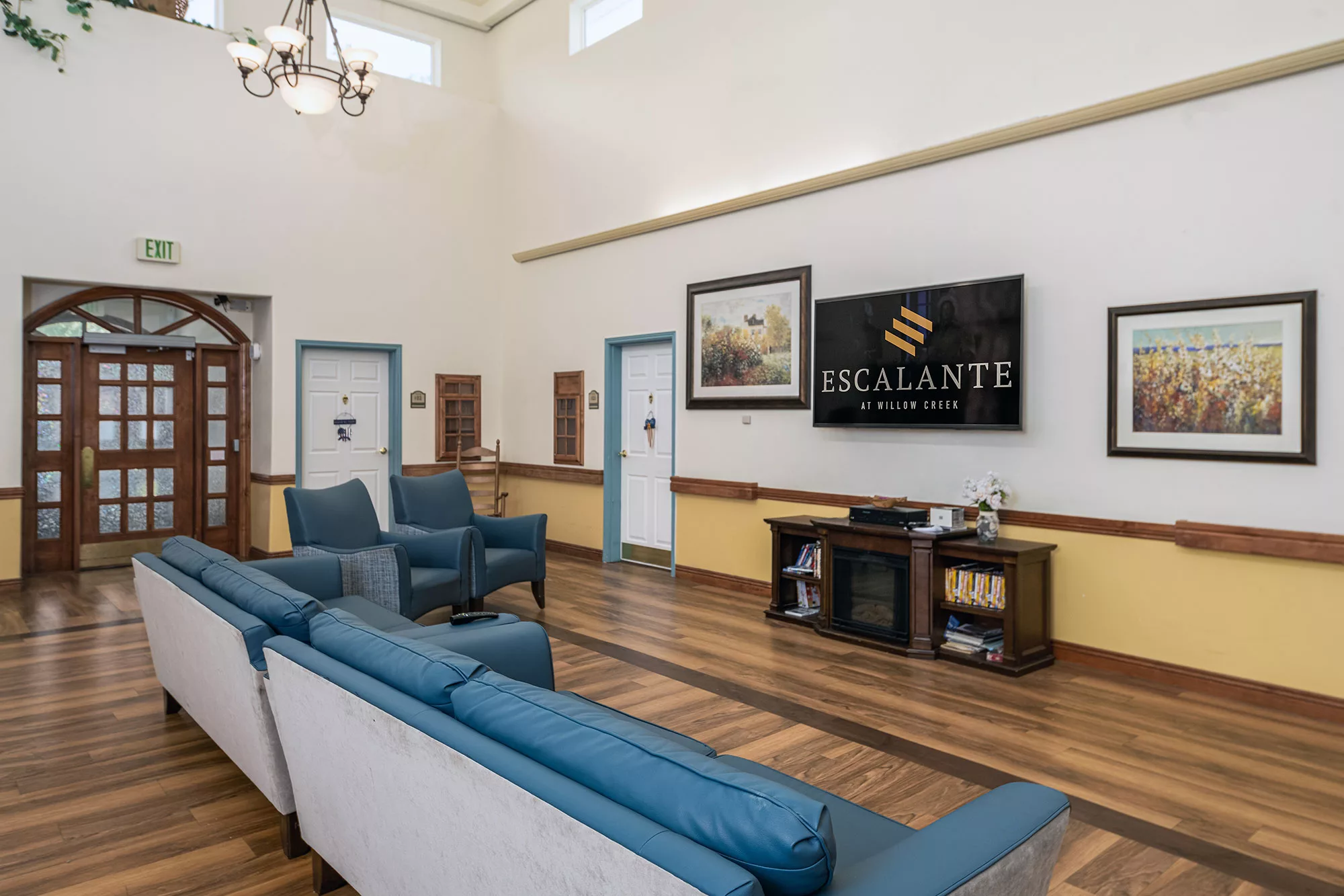 A cozy lobby area featuring comfortable seating, a large television, and elegant decor.