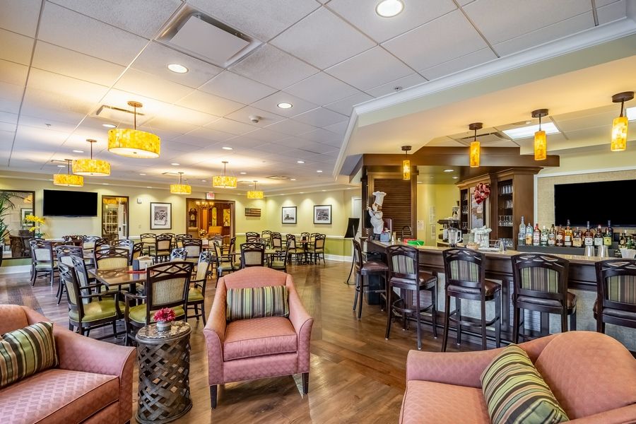 A cozy lounge area with comfortable seating and a bar, featuring warm lighting and stylish decor.