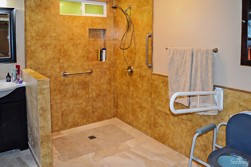 Accessible bathroom with walk-in shower and handrails.