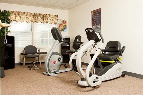 A small indoor gym room with exercise bikes and a desk area.