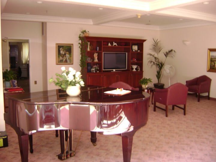 A cozy living room with a grand piano and elegant furnishings.