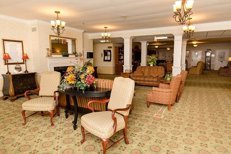 A warmly decorated hotel lobby with elegant furniture and floral arrangements.
