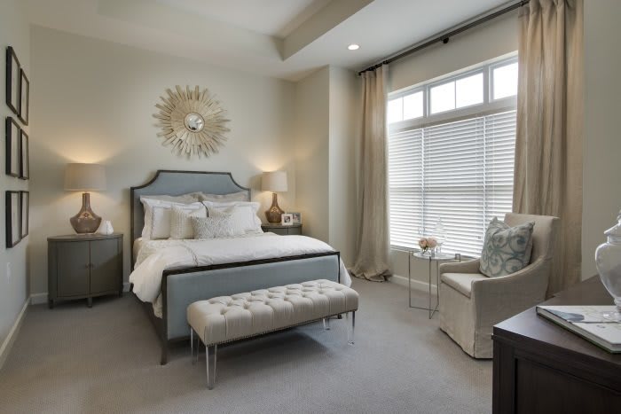 A modern, luxurious bedroom with elegant decor and neutral tones.
