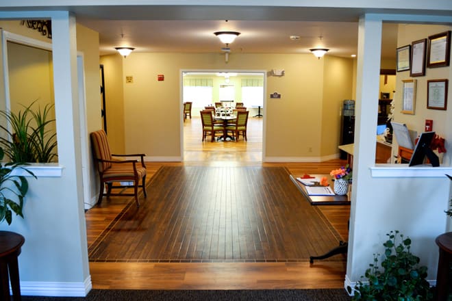A spacious hallway with wood flooring leading to a dining area.