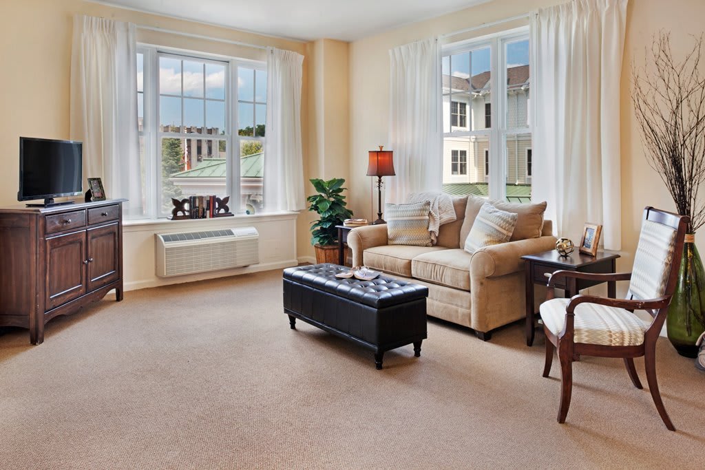 A bright and cozy living room with a sofa, coffee table, and large windows.