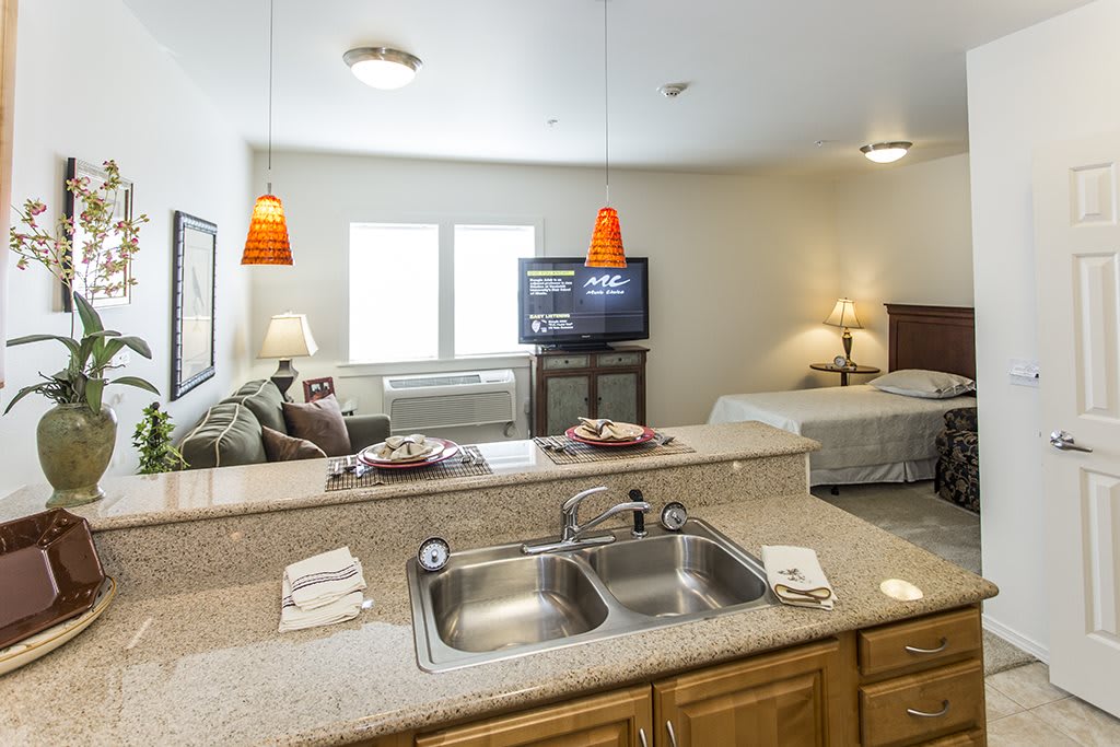 A modern studio apartment features an open floor plan with a kitchen and living area.