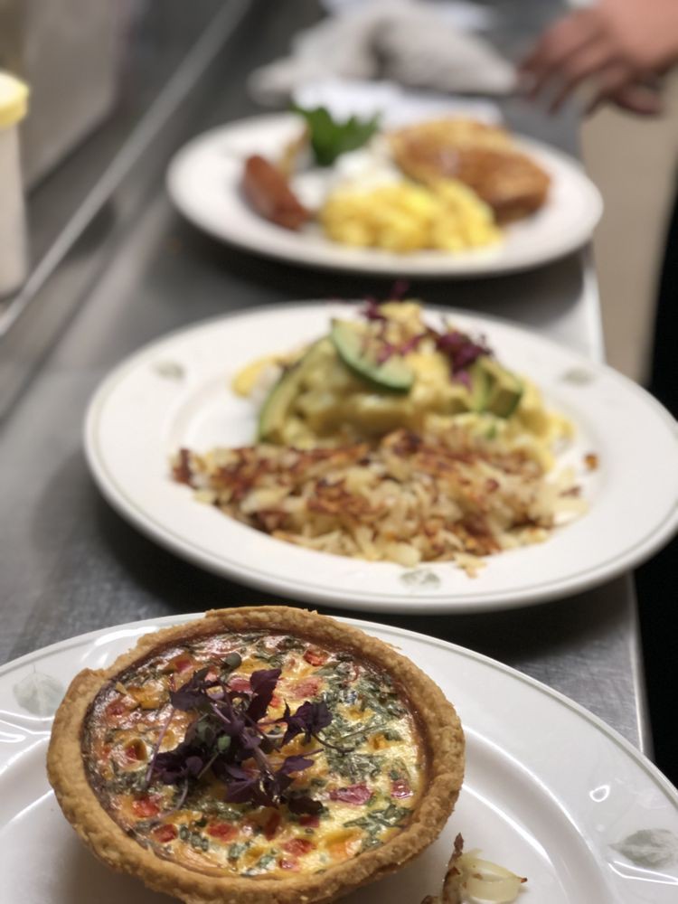 A selection of elegantly plated dishes featuring quiche and pasta.