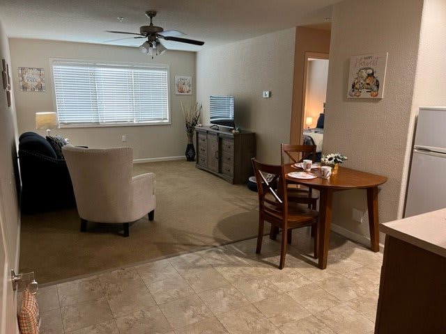 A cozy living room with a dining area, featuring a television and comfortable furniture.
