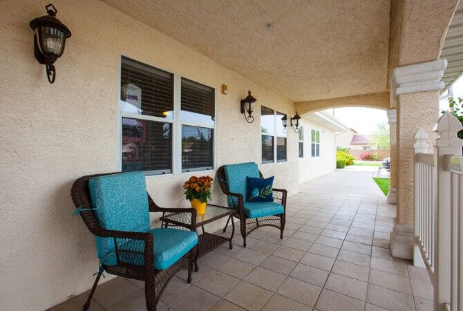 A cozy patio area with blue cushioned chairs and a small table, perfect for relaxation.