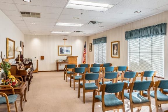 A small chapel with rows of chairs, a pulpit, and an American flag.