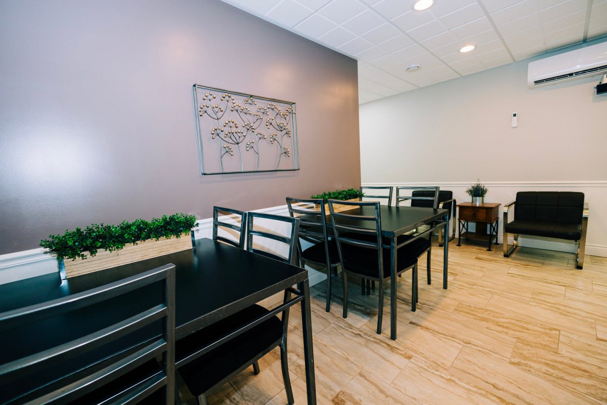 A modern dining area with minimalist decor and neatly arranged tables and chairs.