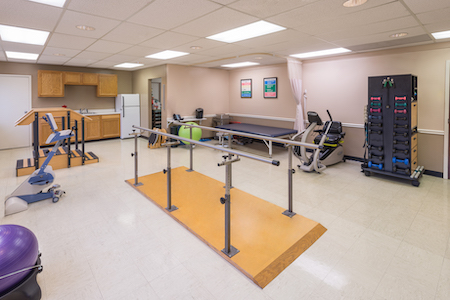 A rehabilitation center featuring parallel bars for physical therapy.