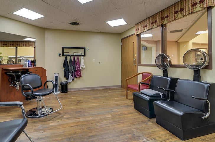 A cozy salon interior with seating and hair styling equipment.